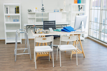 A doctor's office, medical office or examination room, professional environment for patients, features table desk with chairs, workplace near window