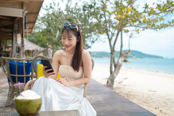 A woman is sitting on a wooden deck with a coconut in front of her
