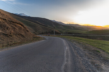 Mountain road, serpentine in Kyrgyzstan at sunset.
