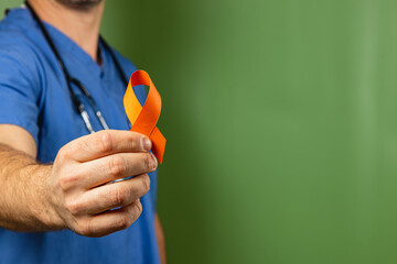 Healthcare worker shows support with orange awareness ribbon for health causes