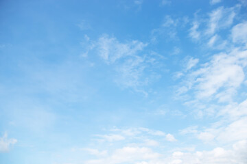 Blue sky background and white clouds soft focus, space in the middle, horizontal shape.