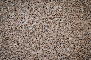 A close-up view of crushed gray stones forming a rough, textured surface, ideal for construction or landscaping projects..