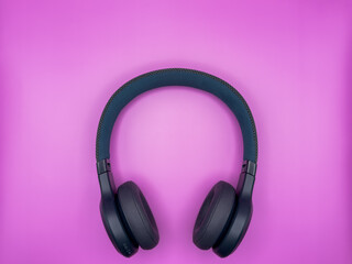 Full-size large headphones made of green plastic with soft earphones and a soft headband lie in the...