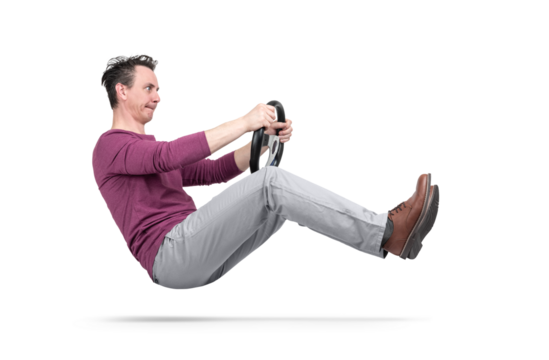Man simulating driving pose, suspended in air, holding a steering wheel. PNG with transparent background. Creative concept of movement, humor, control, speed, imagination.