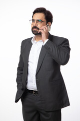 Portrait of Indian business corporate man taking  on mobile phone on white background. Concept of digital and business technology