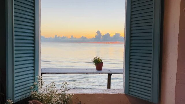Looking at sunrise sea view through opening window. Bedroom interior of resort  on the summer beach.