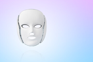 Cosmetic LED facial mask regenerative treatment on a gradient blue background. Health and beauty of the face. Taking care of yourself and your face, anti-aging, prolonging youth and beauty