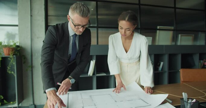 Architects reviewing blueprint in modern office space