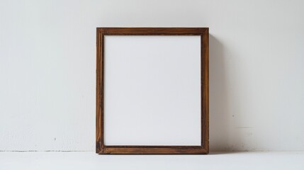 Empty wooden frame ready for artwork display on plain wall in bright room