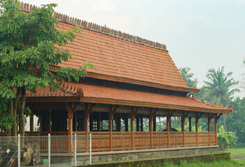 Old pendopo with a brown wooden building, attractive and charming with a background of green trees