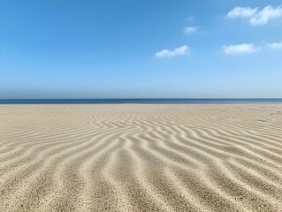 Serene beach landscape with wavy sand patterns under a clear blue sky. Ideal for travel, nature, and serenity themes.