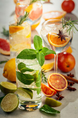 Refreshing summer cocktails with citrus on a white marble table.