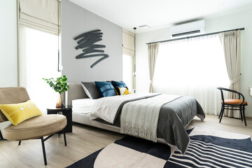 Interior of white, yellow and blue pillow in cozy modern bedroom. Art sculpture on wall.