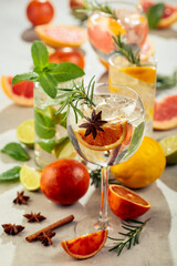 Refreshing summer cocktails with citrus on a white marble table.