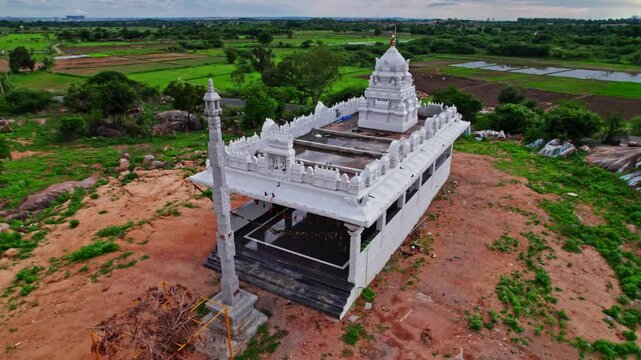 Temple with gopuram in the background farming land and trees at day time, semi circle, drone shot, 4k.