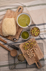 Zutaten für trendige Dubai-Schokolade mit Pistazie – Flatlay mit Fadenteig, Pistazien und Pistaziencreme