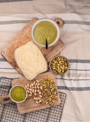 Zutaten für trendige Dubai-Schokolade mit Pistazie – Flatlay mit Fadenteig, Pistazien und Pistaziencreme