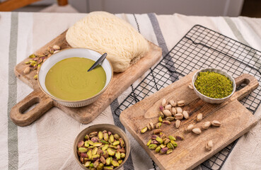 Zutaten für trendige Dubai-Schokolade mit Pistazie – Flatlay mit Fadenteig, Pistazien und Pistaziencreme