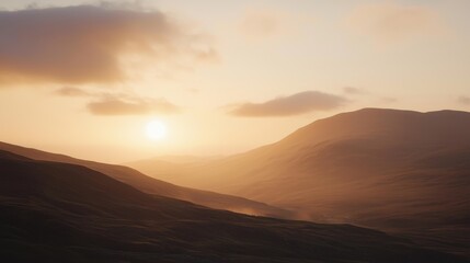 Obraz premium Hazy mountain range lit by a soft sunset glow with textured clouds above