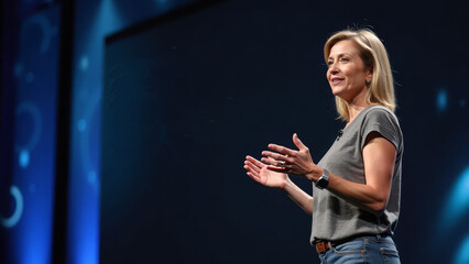 A confident female CEO in her 40s presenting a new product at a tech conference
