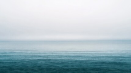 Obraz premium Ocean landscape with calm water and soft reflections under cloudy sky, serene coastal view, minimalistic nature scene, tranquil seascape, peaceful environment.