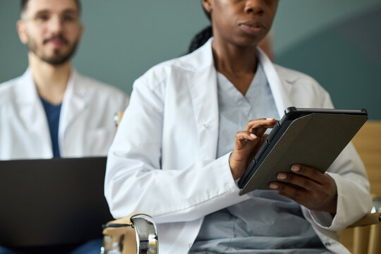 Healthcare professionals focused on data documentation during medical procedures using digital tablets, emphasizing collaborative teamwork in a clinical setting
