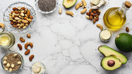 Fototapeta premium Healthy Nutrients: A diverse array of nuts and seeds, alongside fresh avocados, and nourishing oils are artfully arranged on a marble surface. An overhead shot.