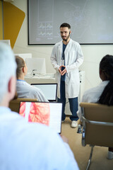 Obraz premium Educating a group of diverse students in modern laboratory room with presentation screens and laboratory equipment in background, engaging students with hands-on demonstration