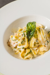 Top view of Fettuccine Alfredo on dark grey stone table