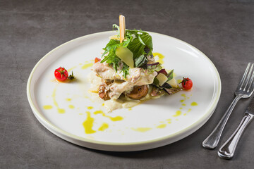 Grilled chicken with mushrooms and cream sauce on a dark stone table