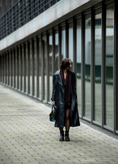 .Young woman standing in front of an office building on the streets of Stuttgart, Germany