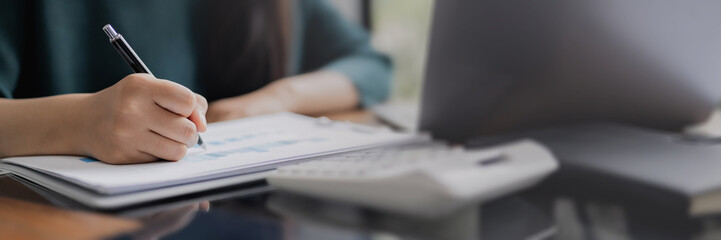 Close up hand holding pen pointing on documents in office