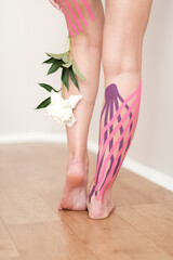Leg taping, close-up of female slender legs on light background. High quality photo