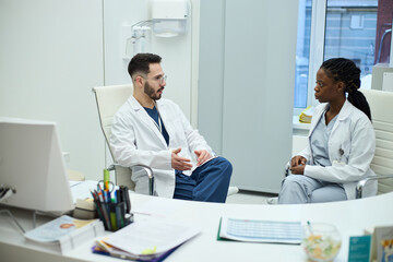 Obraz premium Medical professionals engaged in intense discussion in an office setting against a background of modern medical equipment. Both are in uniforms, emphasizing their dedication to healthcare