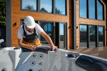 Plumber installing hot tub. Spa technician performing hot tub. Bathtub plumbing. Plumber fixing spa...