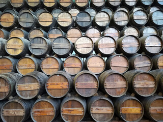 Rustic wooden wine barrels rest in dimly lit cellar	

