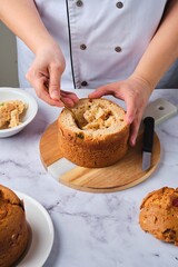 A woman cuts out the center of a baked cupcake to fill it with cream or other filling. Cook's work in the kitchen.