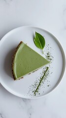 Single Slice of Matcha Cheesecake on Pristine White Plate Garnished with Matcha Powder Line and Matcha Leaf