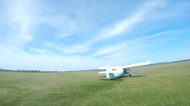 Airplane riding along rural runway before the take-off. Old aircraft heading towards airstrip for before flight at airfield. Retro plane preparing to fly. Aviation concept. Aerial shot from drone