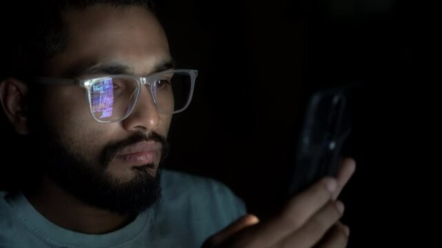 An adult indian man smartphone user doomscrolling through social media content