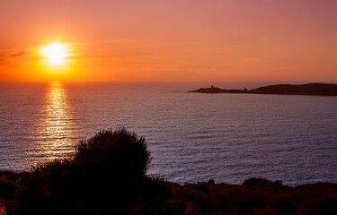 Omigna Genoese tower at sunset, in the Corsican maquis, Cargèse, Corsica island, France. Typical tower in tourist trail on the Mediterranean Corsican coast.