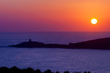 Omigna Genoese tower at sunset, in the Corsican maquis, Cargèse, Corsica island, France. Typical tower in tourist trail on the Mediterranean Corsican coast.