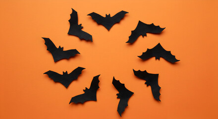 Festive Halloween Decoration Featuring Black Bats Arranged in Circle on Orange Background