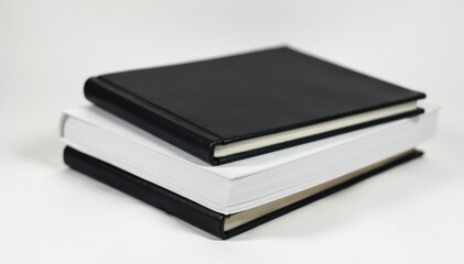Simple black leather binding on a stack of empty white pages, standing upright as a decorative piece, desk organizer, home office essentials