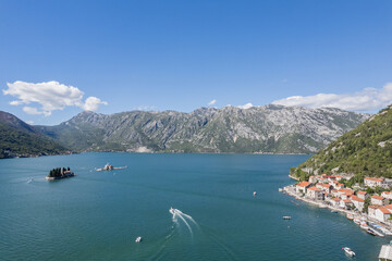 Motor boat sails along the Bay of Kotor to the island of St. George. Montenegro. Drone