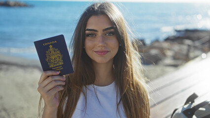 Woman holding canadian passport by seaside promenade, showcasing vibrant sea backdrop with youthful charm and confident demeanor.