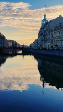 Russia, April 09, 2024: The channel in St. Petersburg in the spring. Bridges and historical buildings on the river embankment, people walking along the embankment. Reflections of houses in the water. 