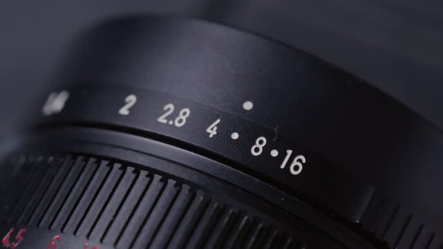 Closeup: Aperture ring changing on camera old Lens, adjusting F-Stop number and iris, showing aperture scale and ring shifting. Professional photographer adjusting lens aperture stop. Close up shot
