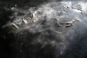 Dark flour scattered across a sleek cooking surface enhances the culinary ambience.