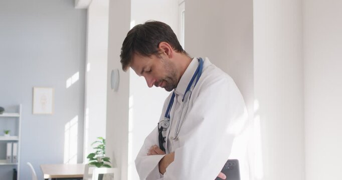 Sad stressed frustrated doctor, male nurse wearing white uniform with stethoscope in hospital, gp feeling desperate and guilty for medical clinic failure, death worry, wrong diagnosis, sorrow